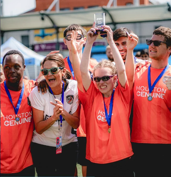 United Genuine FC athletes lifting a trophy